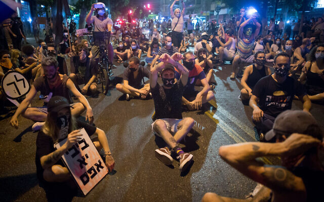 Protesters block a road as they protest against Prime Minister Benjamin Netanyahu in Tel Aviv on September 30, 2020. (Miriam Alster/Flash90) Protesters block a road as they protest against Prime Minister Benjamin Netanyahu in Tel Aviv on September 30, 2020. (Miriam Alster/Flash90)