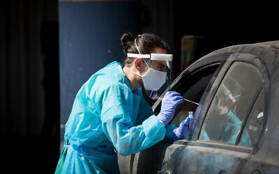 Medical team member takes a swab from a woman to test for the coronavirus disease at Shaare Zedek hospital in Jerusalem on September 30, 2020 (Nati Shohat/Flash90)