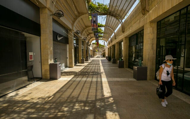 A woman walks next to closed shops in Jerusalem on October 1, 2020 (Olivier Fitoussi/Flash90) A woman walks next to closed shops in Jerusalem on October 1, 2020 (Olivier Fitoussi/Flash90)