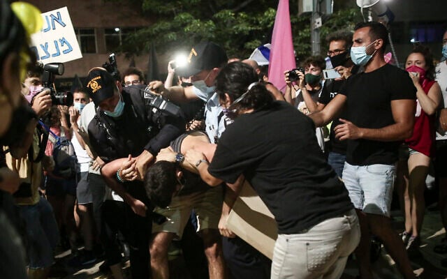 Police officers remove a protestor during protests against Prime Minister Benjamin Netanyahu at Habima Square in Tel Aviv on October 3, 2020. (Miriam Alster/Flash90) Police officers remove a protestor during protests against Prime Minister Benjamin Netanyahu at Habima Square in Tel Aviv on October 3, 2020. (Miriam Alster/Flash90)