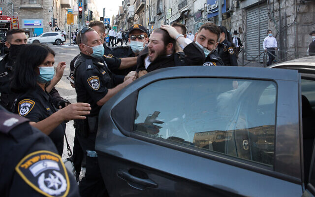Police officers clash with ultra-Orthodox protesters during a demonstration against the enforcement of coronavirus regulations in Mea Shearim, Jerusalem, October 4, 2020 (Nati Shohat/Flash90) Police officers clash with ultra-Orthodox protesters during a demonstration against the enforcement of coronavirus regulations in Mea Shearim, Jerusalem, October 4, 2020 (Nati Shohat/Flash90)