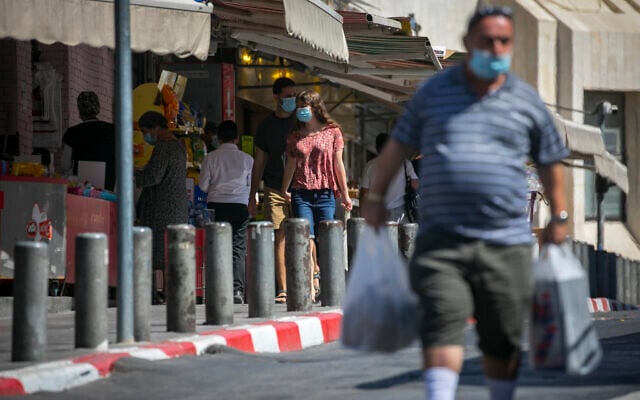 People wearing face masks shop at the Mahane Yehuda Market in Jerusalem on October 5, 2020, during a nationwide lockdown to prevent the spread of COVID-19. (Olivier Fitoussi/Flash90) People wearing face masks shop at the Mahane Yehuda Market in Jerusalem on October 5, 2020, during a nationwide lockdown to prevent the spread of COVID-19. (Olivier Fitoussi/Flash90)