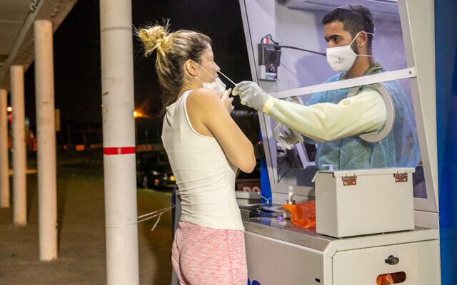 Israelis perform tests for the coronavirus at a Maccabi Test Center, in Ramle. October 5, 2020. (Yossi Aloni/FLASH90) Israelis perform tests for the coronavirus at a Maccabi Test Center, in Ramle. October 5, 2020. (Yossi Aloni/FLASH90)