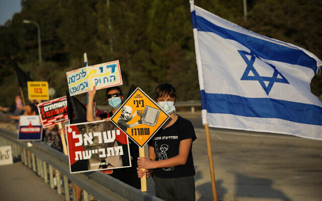 Activists protest against Prime Minister Benjamin Netanyahu on Route 3, in central Israel, October 10, 2020 (Nati Shohat/Flash90) Activists protest against Prime Minister Benjamin Netanyahu on Route 3, in central Israel, October 10, 2020 (Nati Shohat/Flash90)