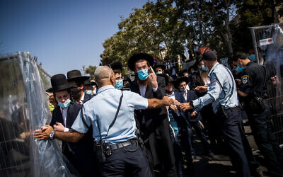 Police guard as ultra-Orthodox Jews attend the funeral of Rabbi Yechezkel Koren in the Bayit VeGan neighborhood of Jerusalem on October 12, 2020. (Yonatan Sindel/Flash90)
