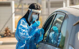 Illustrative: Clalit Health care workers take test samples for coronavirus at a drive-through site in Lod, on October 16, 2020. (Yossi Aloni/Flash90)