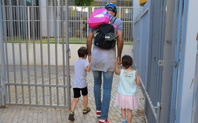 Parents accompany their children to the kindergarten in Tel Aviv as they return to kindergarten on October18, 2020, after being shut down during a national lockdown to prevent the spread of the Coronavirus. (Avshalom Sassoni/Flash90) Parents accompany their children to the kindergarten in Tel Aviv as they return to kindergarten on October18, 2020, after being shut down during a national lockdown to prevent the spread of the Coronavirus. (Avshalom Sassoni/Flash90)