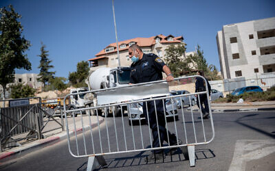 Police guard at a temporary checkpoint in the entrance to the neighborhood of Ramat Shlomo in Jerusalem, in order to prevent the spread of the coronavirus, on October 18, 2020. (Yonatan Sindel/Flash90)