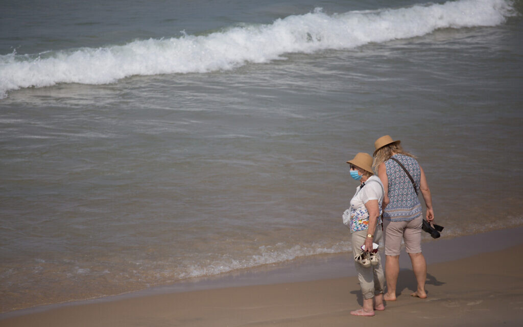 Israelis wear protective face masks on the beach in Tel Aviv on October 28, 2020. (Miriam Alster/Flash90) Israelis wear protective face masks on the beach in Tel Aviv on October 28, 2020. (Miriam Alster/Flash90)