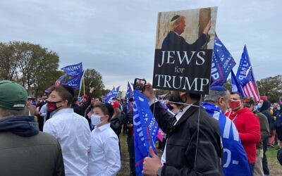 People gather near the stage of a pro-Trump rally at Marine Park in Brooklyn, New York on October 25, 2020. (Jacob Magid/Times of Israel)