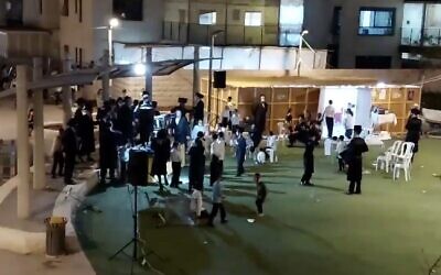 Screen capture from video filmed at the start of an alleged mass Sukkot celebration in the Kiryat Belz neighborhood of Jerusalem, October 7, 2020; the reporter who filmed it filed a police complaint, saying he was assaulted by participants. (Twitter)