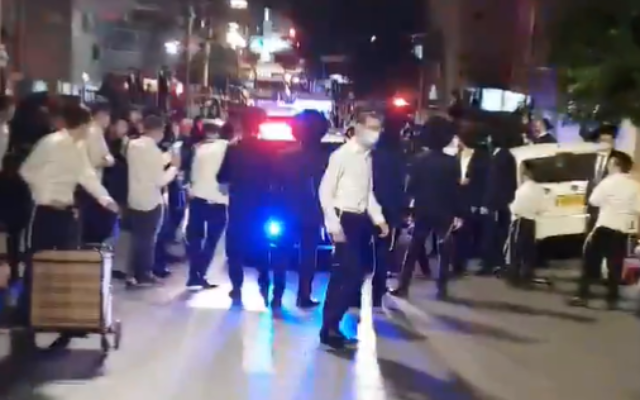 Ultra-Orthodox men block a police vehicle attempting to enforce coronavirus lockdown rules in Bnei Brak, October 4, 2020. (Screenshot: Twitter) Ultra-Orthodox men block a police vehicle attempting to enforce coronavirus lockdown rules in Bnei Brak, October 4, 2020. (Screenshot: Twitter)