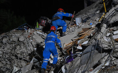 Rescuers search for survivors among the rubble of a collapsed building after a powerful earthquake struck Turkey's western coast and parts of Greece, in Izmir, in the early hours of October 31, 2020. (Ozan Kose/AFP)