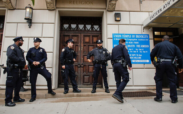 Illustrative: New York police officers stand guard at the door of the Union Temple of Brooklyn, November 2, 2018. (Kena Betancur/AFP/Getty Images via JTA) Illustrative: New York police officers stand guard at the door of the Union Temple of Brooklyn, November 2, 2018. (Kena Betancur/AFP/Getty Images via JTA)
