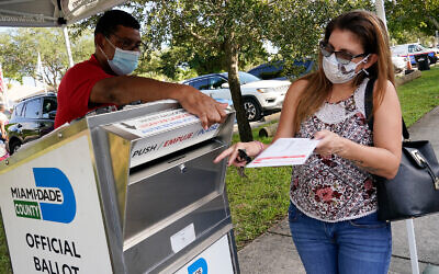 A voter drops off her ballot in North Miami, Florida, October 30, 2020. (AP Photo/Marta Lavandier)
