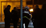French police officers gather outside a high school after a history teacher who opened a discussion with students on caricatures of Islam's Prophet Muhammad was beheaded in Conflans-Saint-Honorine, north of Paris, October 16, 2020. (AP Photo/Michel Euler)