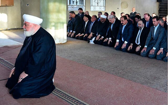Syrian President Bashar Assad, right background, prays during Eid al Adha prayers behind Damascus Mufti Mohammed Adnan Afiouni, foreground, in Daraya town suburb of Damascus, Syria, in a photo released on September 12, 2016 by the Syrian official news agency SANA. (SANA via AP) Syrian President Bashar Assad, right background, prays during Eid al Adha prayers behind Damascus Mufti Mohammed Adnan Afiouni, foreground, in Daraya town suburb of Damascus, Syria, in a photo released on September 12, 2016 by the Syrian official news agency SANA. (SANA via AP)