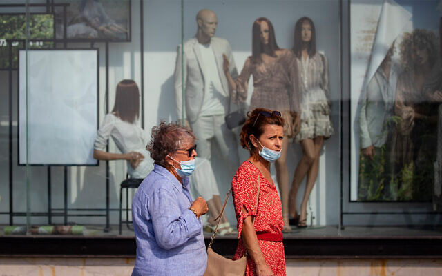 People walk past a closed shop at the Tel Aviv port, October 29, 2020. (Olivier Fitoussi/Flash90) People walk past a closed shop at the Tel Aviv port, October 29, 2020. (Olivier Fitoussi/Flash90)