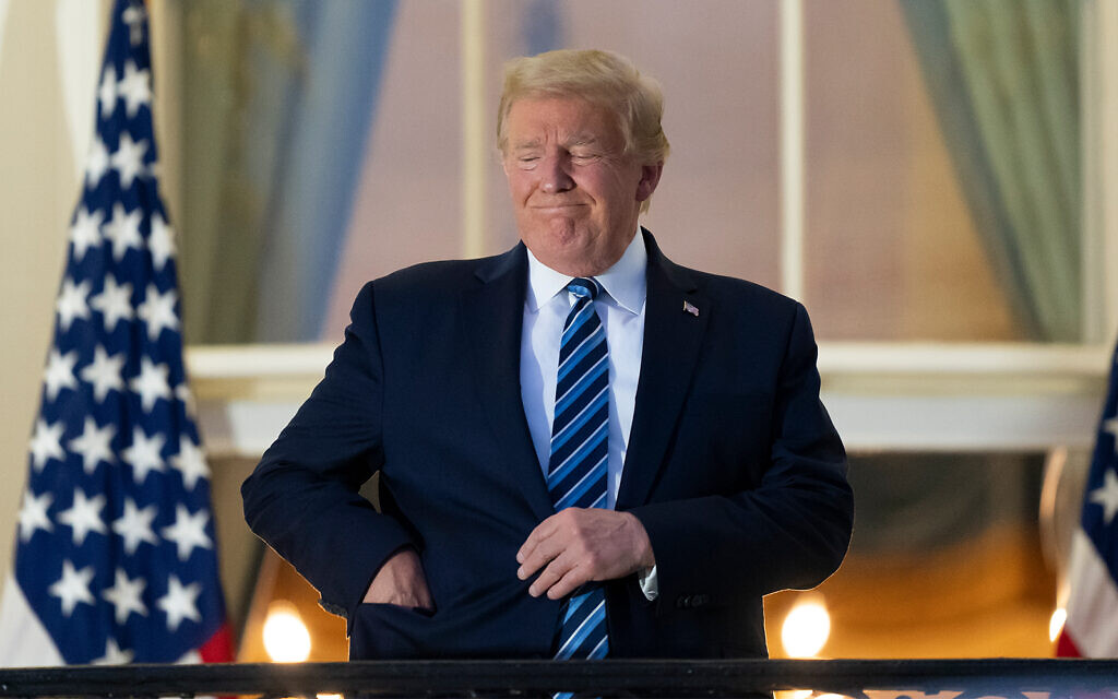 US President Donald Trump puts his mask in his pocket as he stands on the Blue Room Balcony upon returning to the White House from Walter Reed Medical Center, October 5, 2020. (AP Photo/Alex Brandon) US President Donald Trump puts his mask in his pocket as he stands on the Blue Room Balcony upon returning to the White House from Walter Reed Medical Center, October 5, 2020. (AP Photo/Alex Brandon)