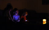 Illustrative: Israelis at home during a power outage in the coastal city of Netanyahu, October 26, 2015. (Chen Leopold/FLASH90)