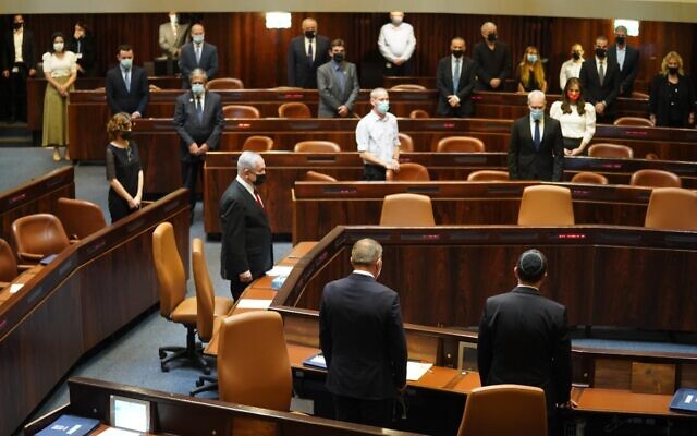 Knesset members hold a minute of silence during a plenum session to mark 25 years since the assassination of prime minister Yitzhak Rabin, October 29, 2020. (Shmulik Grossman/Knesset)