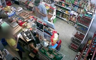 Security footage shows man apologetically robbing Bat Yam grocery store, October 11, 2020 (Screen grab/Channel 12)