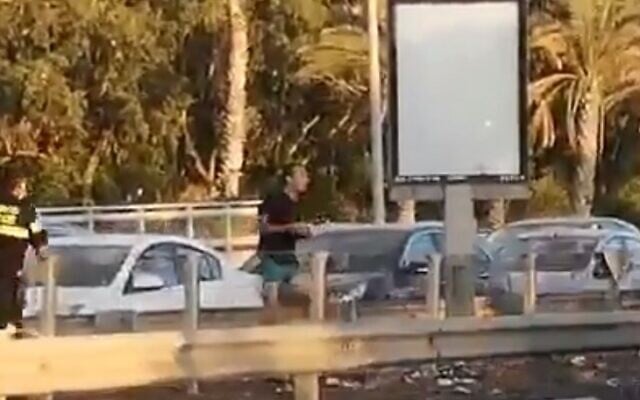 Dennis Potodinsky throwing rocks at anti-Netanyahu protestors. (Screengrab: Twitter)