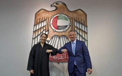In this photo taken on October 27, 2020, Emirati Minister of State for Food and Water Security Mariam al-Muhairi (L) and Erel Margalit, founder and chairman of Jerusalem Venture Partners (JVP), greet each other with an elbow bump at the headquarters of the Government Accelerators in Dubai. (Karim SAHIB / AFP)