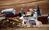 Illustrative: Palestinian bedouins stand next to their belongings after Israeli soldiers demolished their tents in an area east of the village of Tubas, in the West Bank, on November 3, 2020. (AAFAR ASHTIYEH / AFP)