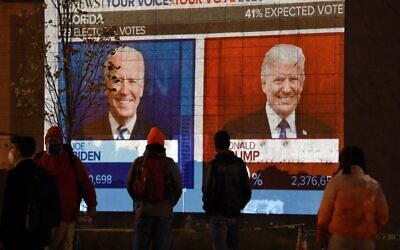 People watch a big screen displaying the live election results in Florida at Black Lives Matter plaza across from the White House on election day in Washington, DC, on November 3, 2020. (Olivier DOULIERY / AFP) People watch a big screen displaying the live election results in Florida at Black Lives Matter plaza across from the White House on election day in Washington, DC, on November 3, 2020. (Olivier DOULIERY / AFP)