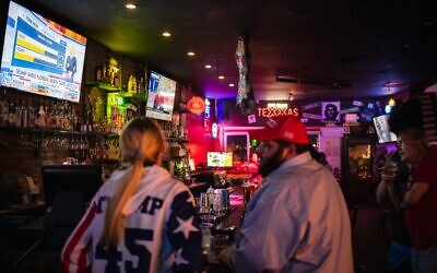 People watch as the election results come in at a pro US President Donald Trump watch party at the Rockin Cigar Bar, in defiance of a county wide shutdown order, in El Paso, Texas on November 3, 2020. (Justin HAMEL / AFP)