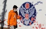 An Iranian man walks past a mural painted on the outer walls of the former US embassy in the Iranian capital Tehran, on November 4, 2020 as the US waits for the results of the presidential election. (ATTA KENARE / AFP)