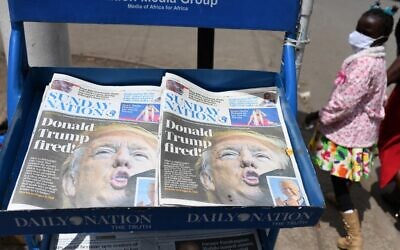 A young girl walks past Kenyan daily newspaper with headline "Donald Trump Fired" in the capital Nairobi on November 8, 2020. (Photo by Simon MAINA / AFP)