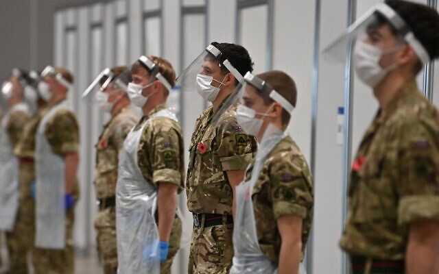 Soldiers observe a 2-minute silence for Armistice Day in remembrance of the nations war dead on November 11, 2020 at a coronavirus rapid-testing center in Liverpool, northwest England. (Paul ELLIS/AFP) Soldiers observe a 2-minute silence for Armistice Day in remembrance of the nations war dead on November 11, 2020 at a coronavirus rapid-testing center in Liverpool, northwest England. (Paul ELLIS/AFP)