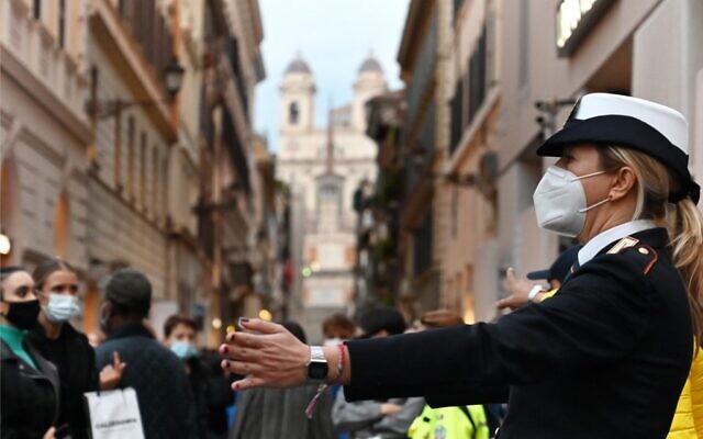 A municipal police officer wearing a face mask controls pedestrian traffic on Via dei Condotti shopping street in downtown Rome on November 14, 2020, during the Covid-19 pandemic caused by the novel coronavirus. (Alberto PIZZOLI / AFP) A municipal police officer wearing a face mask controls pedestrian traffic on Via dei Condotti shopping street in downtown Rome on November 14, 2020, during the Covid-19 pandemic caused by the novel coronavirus. (Alberto PIZZOLI / AFP)