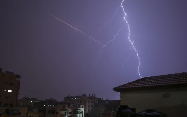 This picture taken from Gaza City shows lightning flashing over buildings as the flare of a rocket launch is seen nearby during a thunderstorm in Gaza city on November 15, 2020. (MOHAMMED ABED / AFP) This picture taken from Gaza City shows lightning flashing over buildings as the flare of a rocket launch is seen nearby during a thunderstorm in Gaza city on November 15, 2020. (MOHAMMED ABED / AFP)