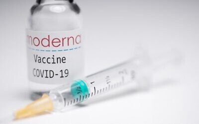 A syringe and a vial with the logo of US biotech firm Moderna. (AFP)