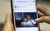A man in Cairo holds a phone showing a picture of Egyptian singer Mohamed Ramadan posted by the official Facebook page of the State of Israel in Arabic showing Ramadan, right, hugging Israeli soccer player Diaa Sabia in Dubai, November 22, 2020. (Khaled Desouki/AFP)