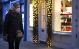A pedestrian wearing a protective face covering to combat the spread of the coronavirus, walks past the Christmas-themed window displays of shops in central London on November 27, 2020, as life under a second lockdown continues in England. (Tolga Akmen / AFP)