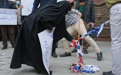 Students of Iran's Basij paramilitary force burn US and Israeli flags during a rally in front of the foreign ministry in Tehran, on November 28, 2020, to protest the killing of prominent nuclear scientist Mohsen Fakhrizadeh a day earlier near the capital. (Atta Kenare/AFP)