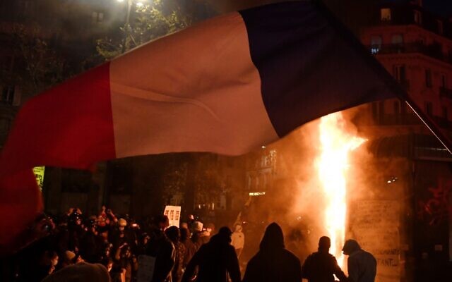 Demonstrators stands next to a fire during a protest against the 'global security' draft law' in Paris, on November 28, 2020. (Alain JOCARD / AFP) Demonstrators stands next to a fire during a protest against the 'global security' draft law' in Paris, on November 28, 2020. (Alain JOCARD / AFP)