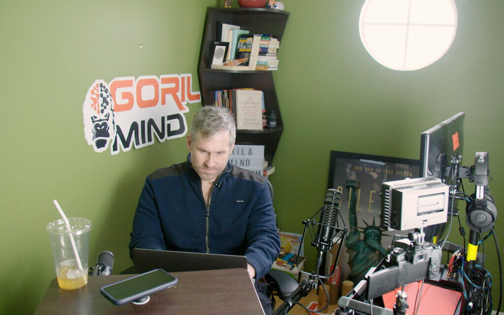 Mike Cernovich, a conspiracy theorist, works at his laptop in the documentary film 'White Noise' by filmmaker Daniel Lombroso. (Courtesy of Lombroso/ via JTA)
