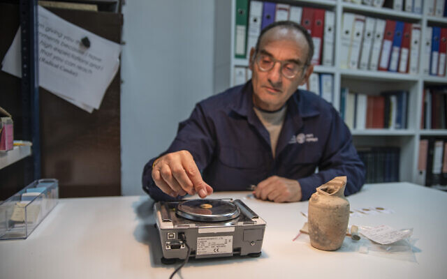 Dr Robert Kool weighs gold coins discovered near Jerusalem's Western Wall (Shai Halevi, Israel Antiquities Authority)
