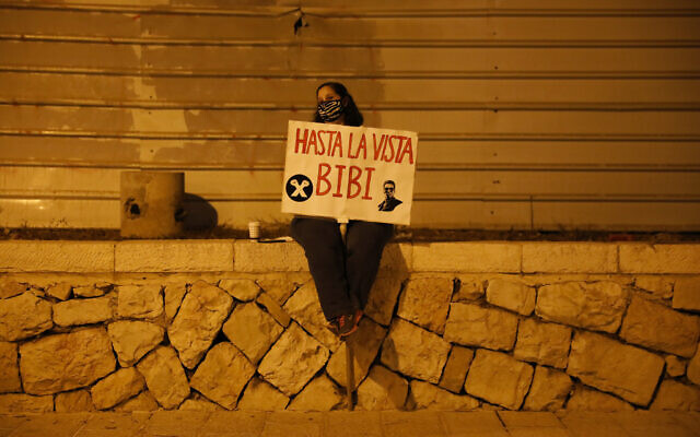 A protester holds a sign during a protest against Israel's Prime Minister Benjamin Netanyahu in Jerusalem, Oct. 31, 2020. (AP Photo/Ariel Schalit) A protester holds a sign during a protest against Israel's Prime Minister Benjamin Netanyahu in Jerusalem, Oct. 31, 2020. (AP Photo/Ariel Schalit)