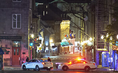 Police cars block the Saint-Louis Street near the Chateau Frontenac early Sunday, Nov. 1, 2020 in Quebec City, Canada. Police in Quebec City early Sunday arrested a man on suspicion of killing two people and injuring five others in a stabbing rampage near the provincial legislature on Halloween. (Jacques Boissinot/The Canadian Press via AP)