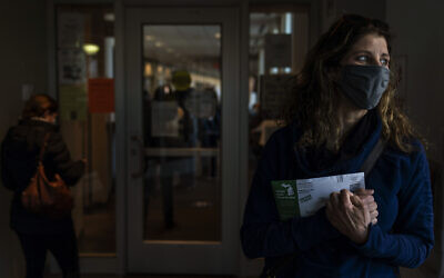 Diane Spiteri clutches her absentee ballot before dropping it off at the city clerk's office in Warren, Michigan, October 28, 2020. (AP Photo/David Goldman)