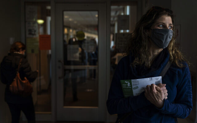 Diane Spiteri clutches her absentee ballot before dropping it off at the city clerk's office in Warren, Michigan, October 28, 2020. (AP Photo/David Goldman) Diane Spiteri clutches her absentee ballot before dropping it off at the city clerk's office in Warren, Michigan, October 28, 2020. (AP Photo/David Goldman)