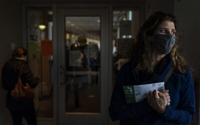 Diane Spiteri clutches her absentee ballot before dropping it off at the city clerk's office in Warren, Michigan,  October 28, 2020. (AP Photo/David Goldman)