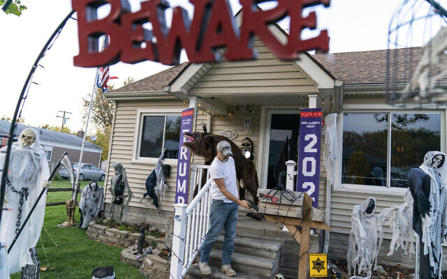 Trump supporter Terry Frandle checks his mailbox in his front yard decorated for Halloween and a Trump reelection campaign in Saint Clair Shores, Michigan, October 28, 2020. (AP Photo/David Goldman)