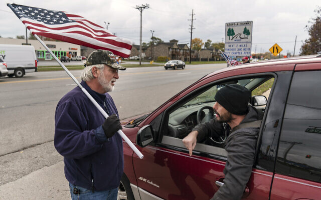 A passing motorist argues with Trump supporter Mike Jamerson during a rally at an intersection in Mount Clemens, Michigan, October 29, 2020. (AP Photo/David Goldman) A passing motorist argues with Trump supporter Mike Jamerson during a rally at an intersection in Mount Clemens, Michigan, October 29, 2020. (AP Photo/David Goldman)